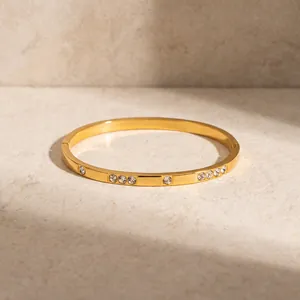 Detail showing 18k gold plated stainless steel bangle with inlaid cubic zirconia