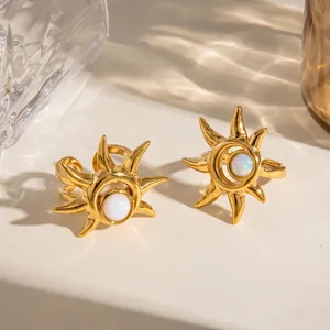 Detailansicht goldener Edelstahlringe in Sonnenform mit weißem Katzenaugenstein