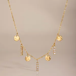 Detailansicht einer goldenen Edelstahlkette mit gehämmerten Scheiben und Strasssteinen.