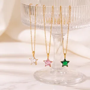 Nahaufnahme von sternförmigen Zirkonia-Anhängern in Weiß, Rosa und Grün an Goldketten.