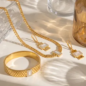 Detailansicht eines geometrischen Schmucksets mit Strass und weißen Muscheleinlagen.