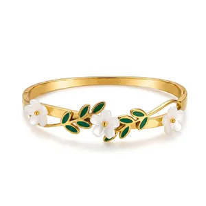 Detailansicht des mit 18k Gold beschichteten Armreifs mit weißen Blumen und grünen Blättern