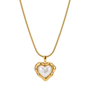 Vista detallada de un collar de acero inoxidable dorado con un colgante de perla corazón