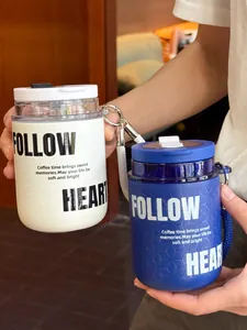 Primo piano di tazze da caffè portatili bianche e blu con scritta 'Follow Heart' e lacci.