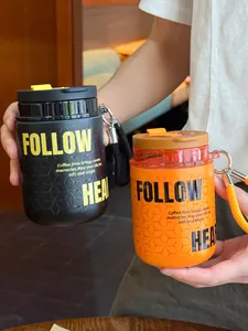 Vista dettagliata di due mini tazze da caffè portatili in acciaio inossidabile nere e arancio