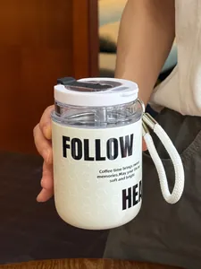 Primo piano di una mini tazza termica bianca dotata di un comodo cinturino portatile