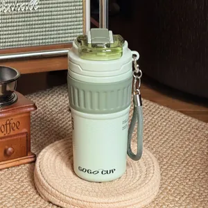 Nahaufnahme einer hellgrünen GOGO CUP Thermotasse auf einem gewebten Untersetzer.