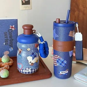Kreative isolierte Edelstahl-Tasse im trendigen Denim-Stil mit Strohhalm und Lederhülle.