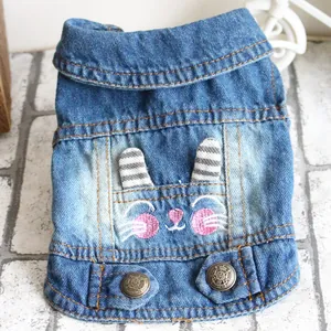 Detailed view of the cute bunny embroidery and striped ears on this blue denim pet vest.