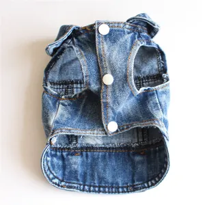 Vista dettagliata della texture denim strappata e dei bottoni di un piccolo gilet per animali.