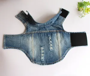 Dettaglio di gilet per cani in denim blu strappato con pratiche chiusure in velcro nero.
