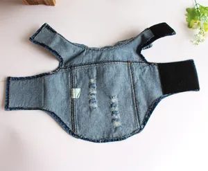 Dettaglio piatto di un gilet in denim strappato per cani che mostra la trama del tessuto.