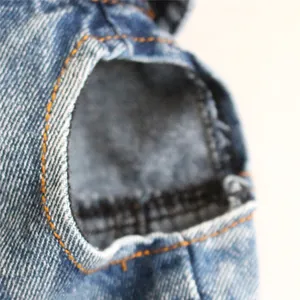 Dettaglio di un gilet in denim per animali con cuciture arancioni a contrasto