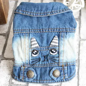 Close-up detail of a blue pet denim vest with cute cat face embroidery and metal buttons