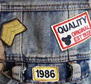 Gedetailleerd overzicht van blauwe spijkerbroek voor honden met vintage patches