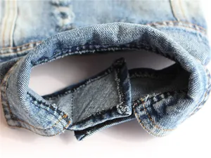 Dettaglio macro del gilet in denim per cani con chiusura a velcro e trama del tessuto
