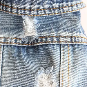 Vista macro dettagliata del tessuto denim distressed e delle cuciture sulla gilet