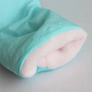 Macro detail of soft pink fleece lining inside a thick cyan pet winter coat for dogs.