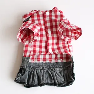 Detail view of a red checkered pet dress with a denim ruffled skirt and buttons.