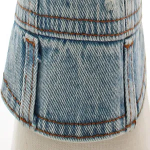 Close-up detail of light blue denim dog vest featuring classic orange contrast stitching