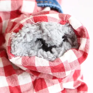 Dettaglio della fodera in pile grigio morbido in una tuta a quadretti per animali.
