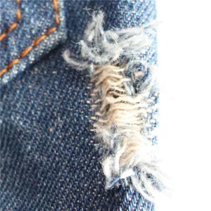 Macro view showing the distressed denim fabric and ripped detail on this pet vest