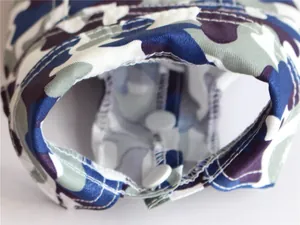 Close-up detail shot of white snap button fasteners on a blue camouflage pet vest