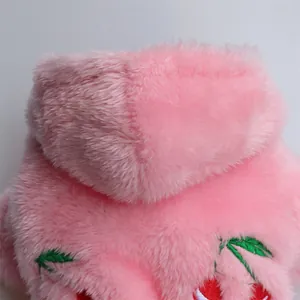 Detalle de primer plano de sudadera rosa de felpa para mascotas con cereza bordada