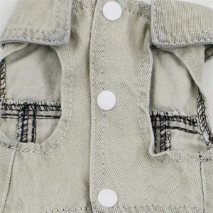 Close-up detail of khaki denim pet vest showing fabric texture and white snap buttons