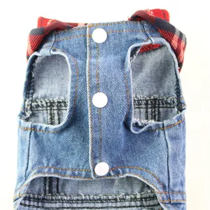 Close-up of dog denim vest featuring snap buttons and a red plaid collar.