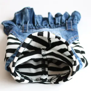 Detailed macro view of striped pet denim dress featuring ruffled skirt and white snap button