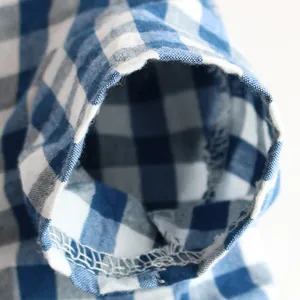 Close-up of blue and white checkered pet clothing sleeve showing hem stitching detail