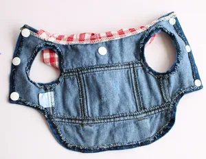 Detail view of blue denim pet vest with red checkered collar and snap buttons.