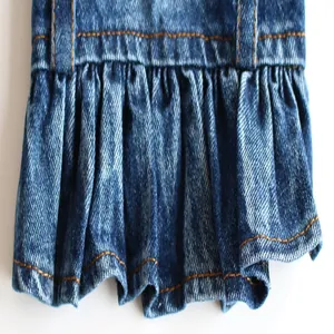 Detailed close-up view of a blue denim pet skirt featuring ruffled hem and yellow stitching