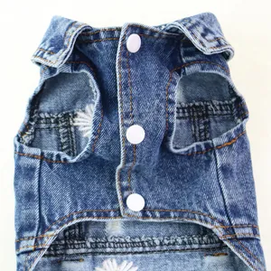 Detailed view of a blue denim pet vest with white buttons and daisy embroidery.