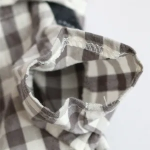 Close-up detail of the stitching on a grey and white checkered pet jumpsuit sleeve.