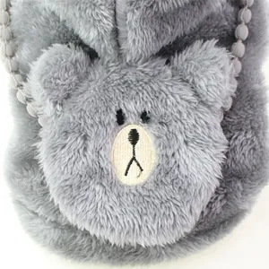 Close-up of grey plush dog garment featuring an embroidered teddy bear face.