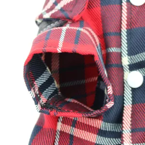 Macro view of the classic red plaid fabric and stitched sleeve opening on a dog jumpsuit