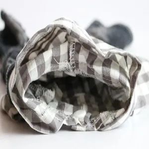 Detailed macro view showing quality stitching and gingham cotton fabric on dog jumpsuit