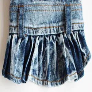 Macro detail shot of blue denim dog skirt showing pleated fabric texture and stitching