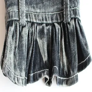 Detailed macro view showing the ruffled hem and white stitching on a dark gray pet denim skirt