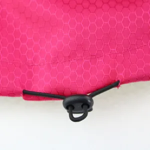 Close-up of the adjustable drawstring toggle on a waterproof pink dog jacket.