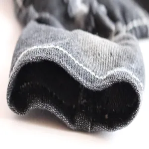 Detailed macro view showing white stitching and texture of dark denim pet clothing