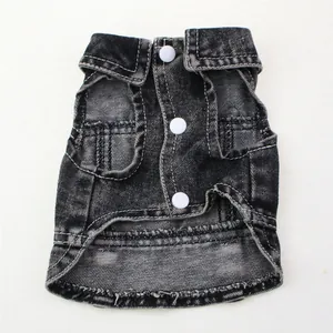 Détail d'un gilet en jean noir usé pour animaux avec boutons-pression blancs.