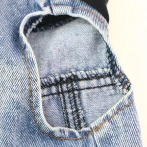 Close-up detail showing the durable stitching on a blue denim vest for small dogs