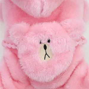Detail of pink plush dog hoodie featuring a cute embroidered bear face texture.