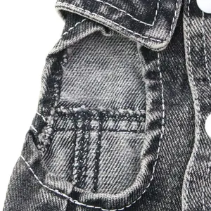 Détail d'un gilet pour animal en denim noir délavé avec coutures blanches et emmanchure