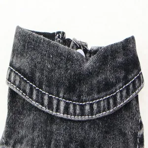 Vue macro montrant la texture détaillée et les coutures blanches d'un col en jean délavé