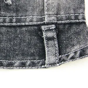 Gros plan montrant les coutures de qualité et le tissu en denim noir résistant du gilet pour animaux