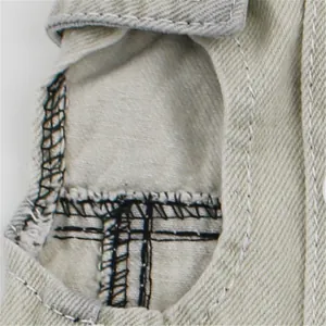 Close-up detail of beige pet denim vest fabric and black stitching for small dogs.